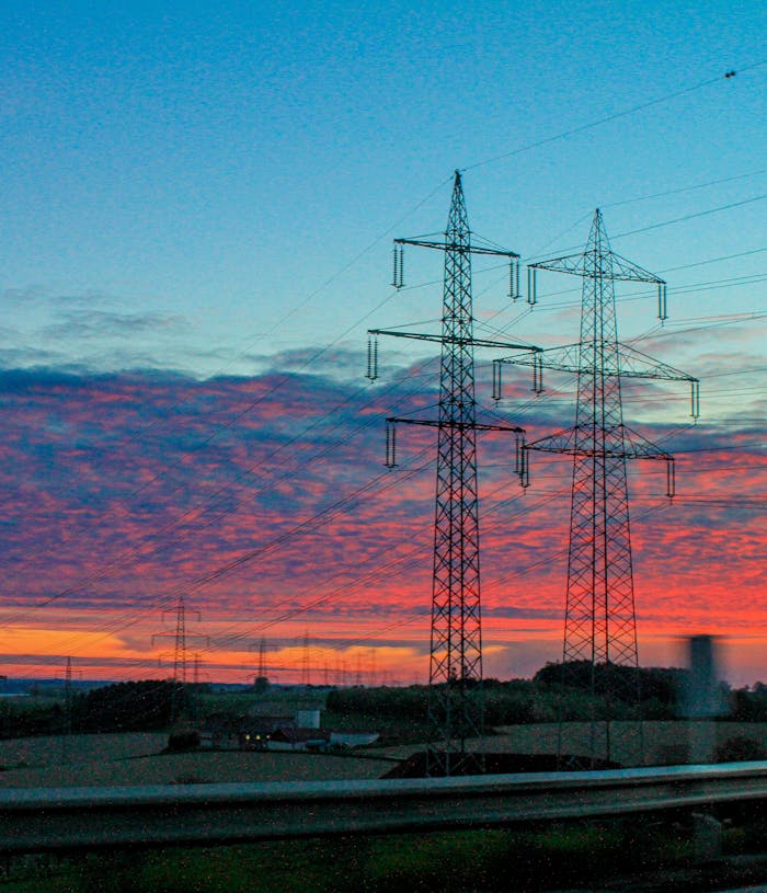 Electricity pylons against a stunning sunset in Austria, illustrating energy and power infrastructure.